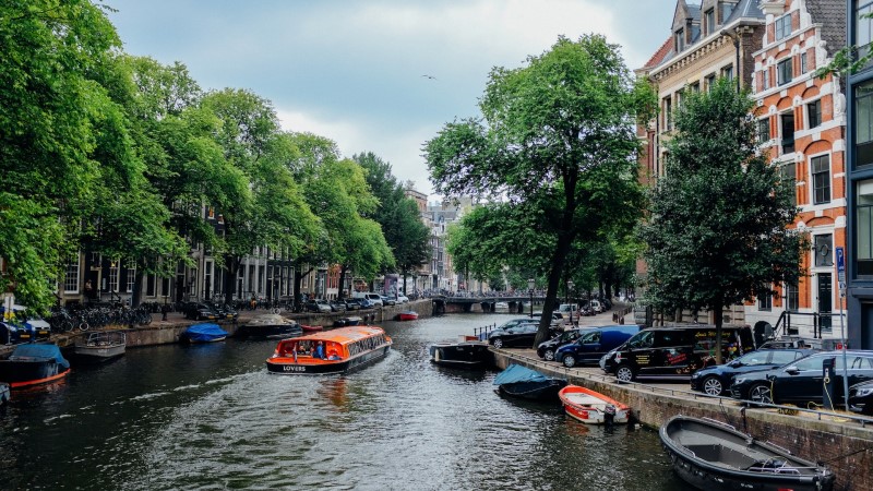 Crucero por los canales de Ámsterdam durante el día entre edificios históricos